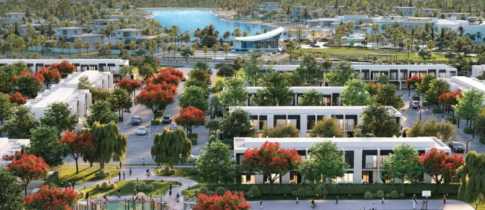 Aerial view of modern villa community with lush green trees and lagoon in Tilal Al Ghaf Dubai